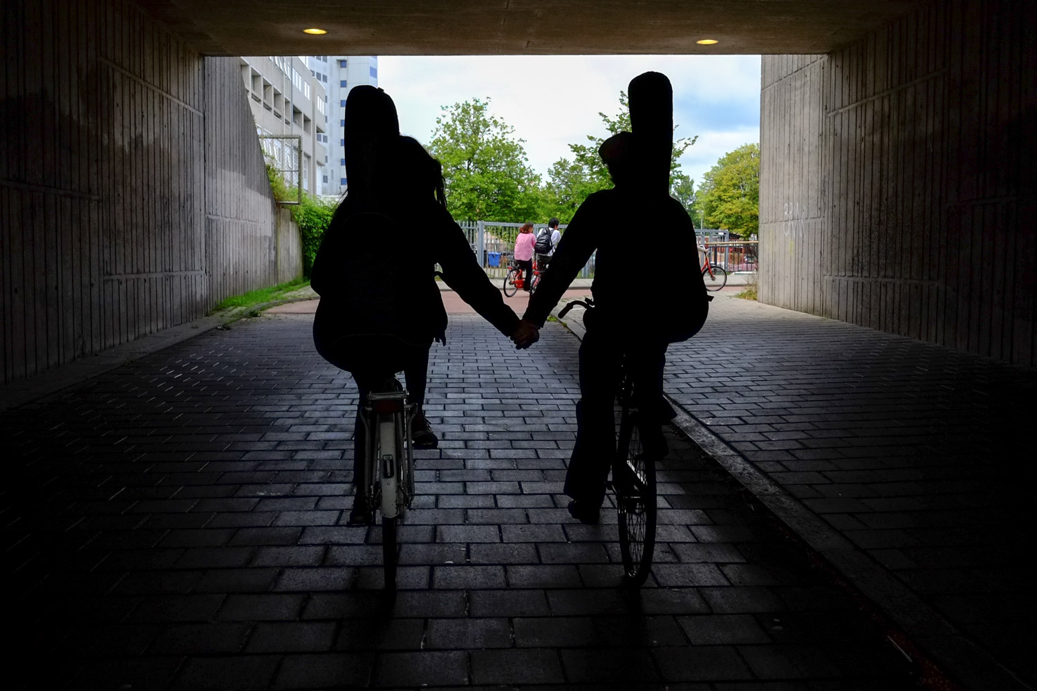 A musical couple rides hand in hand in Amsterdam. Photo by David Niddrie