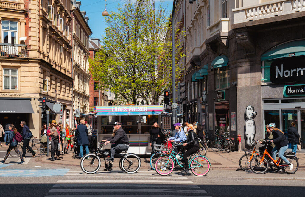 photo of vibrant street life with bicycles, pedestrians and shops