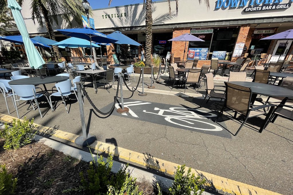 A bike lane in Clearwater Florida covered over with patio tables and chairs from restaurants